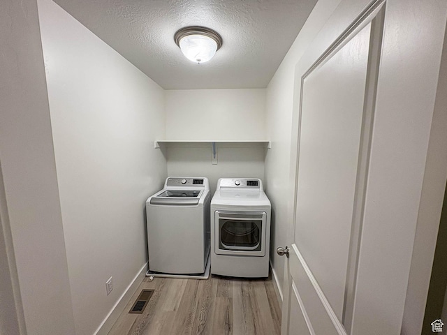 3361 W 3275 N, Plain City, UT 84404 - laundry area with laundry area, light wood finished floors, visible vents, a textured ceiling, and washing machine and dryer