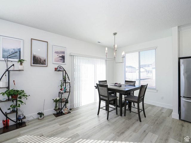 3361 W 3275 N, Plain City, UT 84404 - dining area with light wood-style floors, a textured ceiling, baseboards, and an inviting chandelier