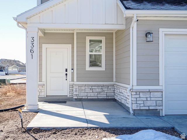 3361 W 3275 N, Plain City, UT 84404 - property entrance featuring a garage, stone siding, board and batten siding, and roof with shingles