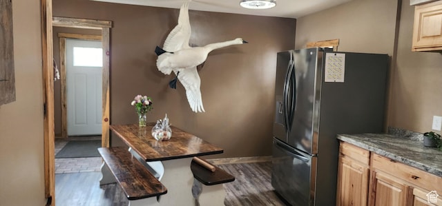 kitchen with stainless steel fridge with ice dispenser, dark wood finished floors, baseboards, and light brown cabinets