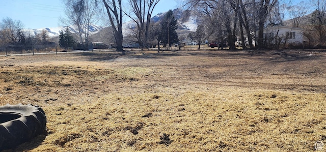 view of yard featuring a mountain view and fence