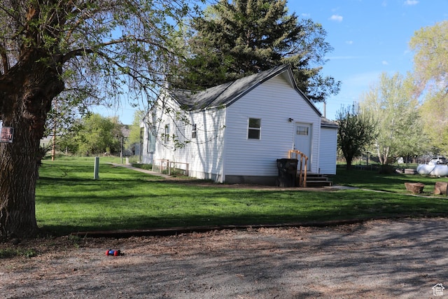 view of home's exterior with a lawn and entry steps