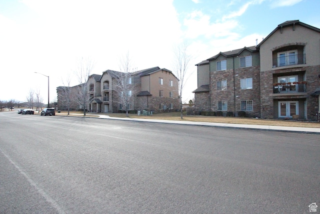 view of road with curbs, sidewalks, and street lights