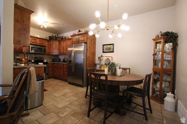 kitchen featuring visible vents, decorative backsplash, brown cabinets, decorative light fixtures, and stainless steel appliances