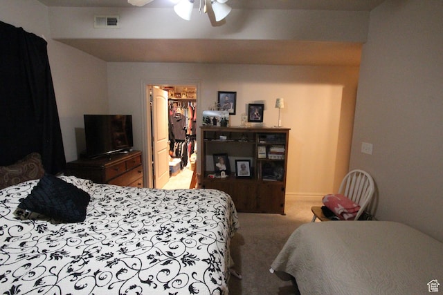 bedroom with visible vents, ceiling fan, carpet, a walk in closet, and a closet