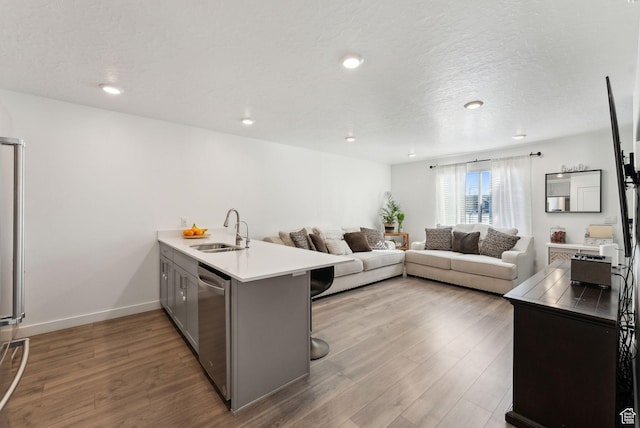 1099 E Quarterdeck Way, Saratoga Springs, UT 84045 - kitchen with a sink, a breakfast bar, gray cabinetry, dishwasher, and a peninsula