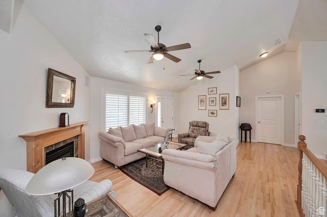 living area with light wood-style floors, ceiling fan, and vaulted ceiling