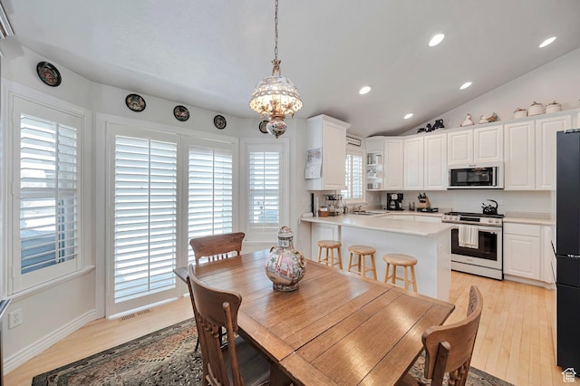 dining room featuring visible vents, light wood-type flooring, recessed lighting, a notable chandelier, and vaulted ceiling