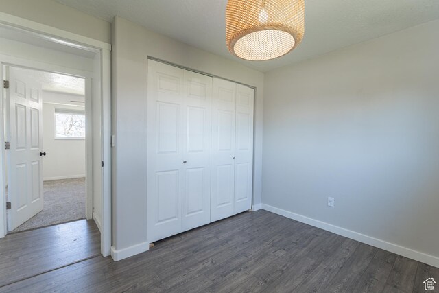 481 E Laurelwood Dr S, Kaysville, UT 84037 - unfurnished bedroom with dark wood-style flooring, a closet, and baseboards
