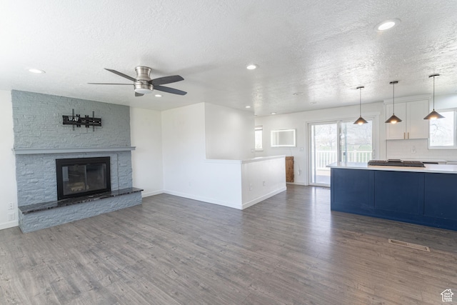 481 E Laurelwood Dr S, Kaysville, UT 84037 - unfurnished living room with a fireplace, dark wood-style flooring, a wealth of natural light, and a ceiling fan