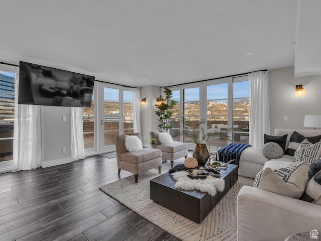living area featuring dark wood-style flooring, french doors, a wall of windows, and plenty of natural light