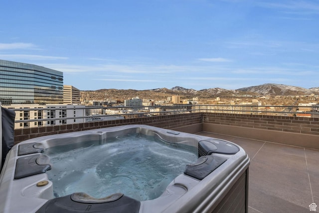 exterior space featuring a hot tub, a mountain view, and a city view