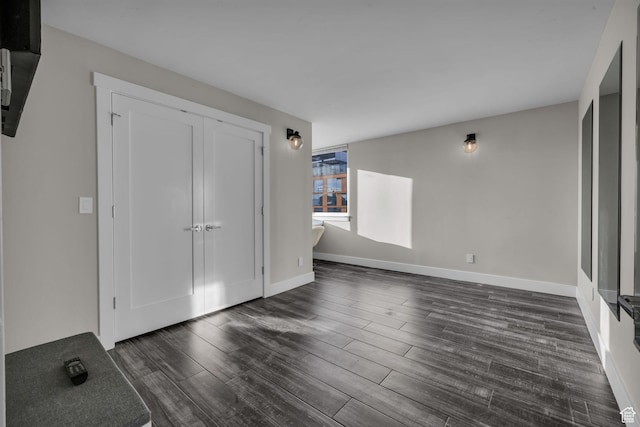 interior space featuring baseboards and dark wood-type flooring