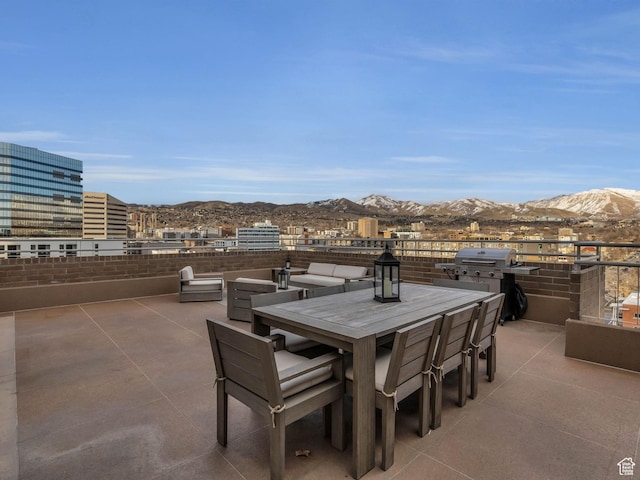 view of patio with outdoor dining area, area for grilling, and a mountain view