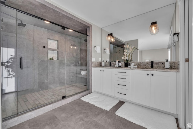 bathroom featuring double vanity, a shower stall, and a sink