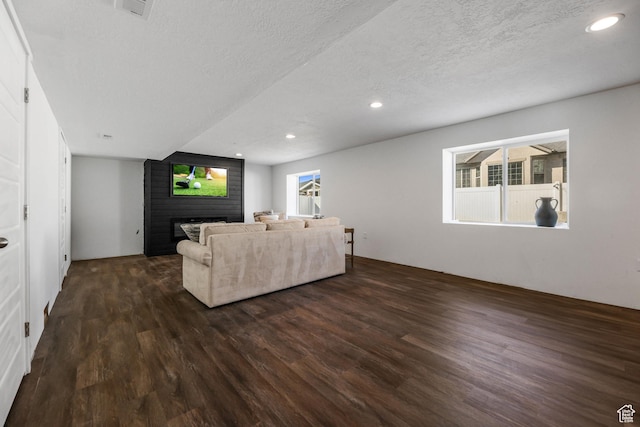 1879 N 925 E, North Ogden, UT 84414 - living area featuring dark wood-type flooring, a brick fireplace, a textured ceiling, and recessed lighting