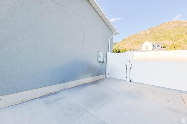 1879 N 925 E, North Ogden, UT 84414 - view of home's exterior with a gate, a mountain view, a patio area, and stucco siding