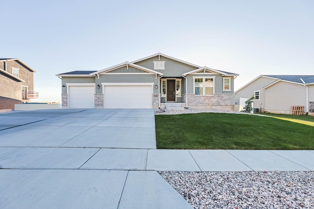 1879 N 925 E, North Ogden, UT 84414 - view of front of house featuring an attached garage, stone siding, driveway, a front lawn, and stucco siding