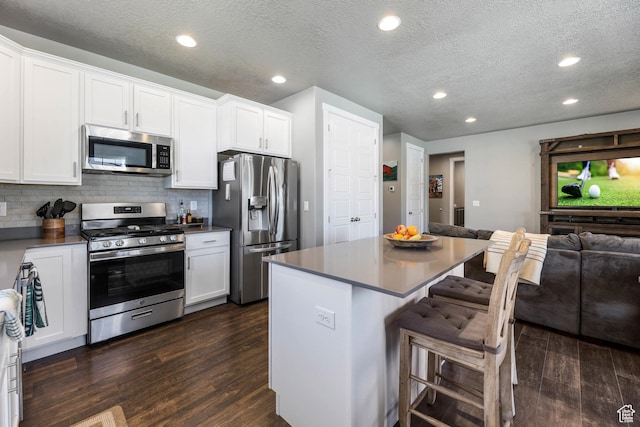 1879 N 925 E, North Ogden, UT 84414 - kitchen with appliances with stainless steel finishes, dark wood-type flooring, open floor plan, a center island, and recessed lighting