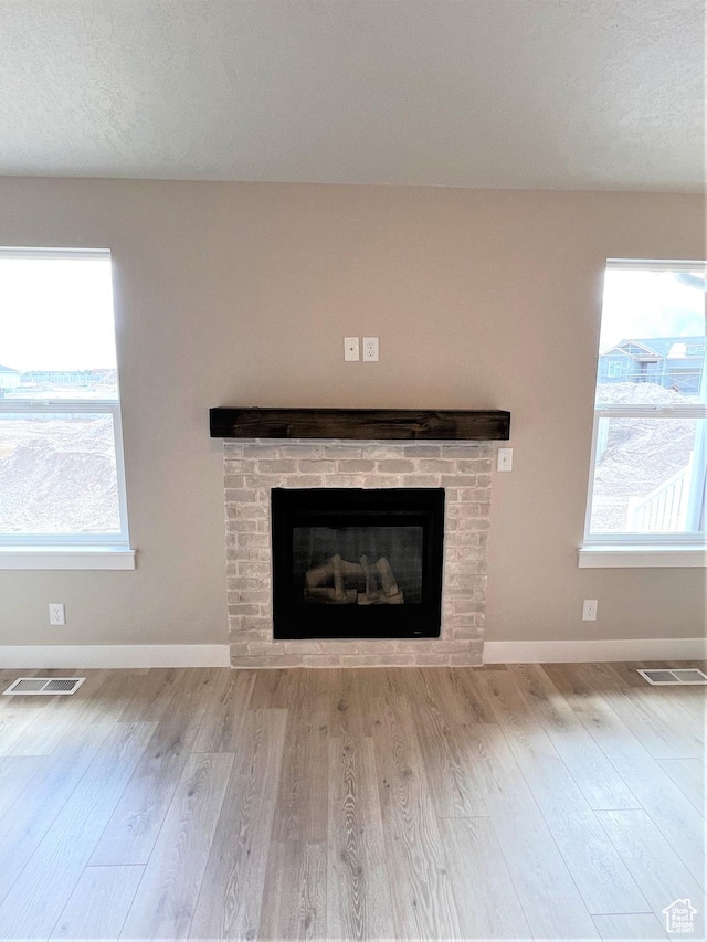 130 S Liberty St Unit 203, Grantsville, UT 84029 - interior details with a brick fireplace, wood finished floors, visible vents, and baseboards