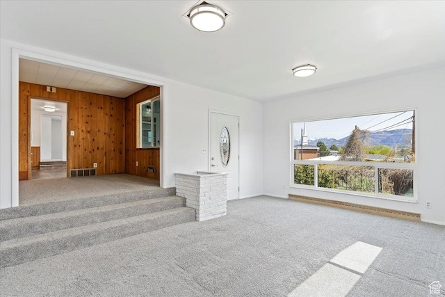 405 W 5100 S, Washington Terrace, UT 84405 - unfurnished living room featuring wooden walls, baseboards, visible vents, carpet flooring, and baseboard heating