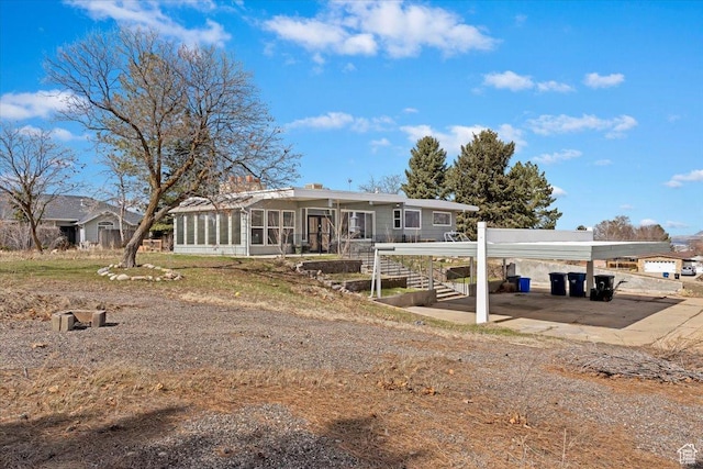 rear view of house with a detached carport and a sunroom
