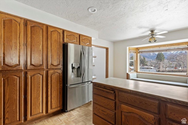 445 W 5100 S, Washington Terrace, UT 84405 - kitchen featuring stainless steel fridge, a ceiling fan, brown cabinetry, and a textured ceiling