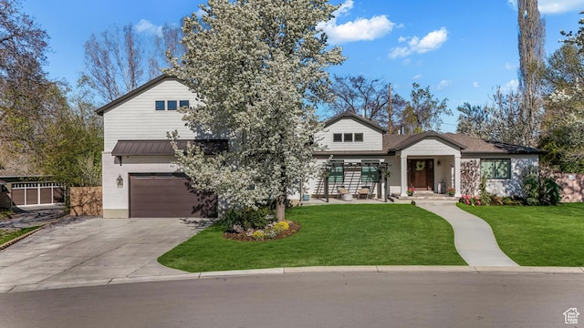 view of front facade featuring a front yard, fence, a garage, and concrete driveway