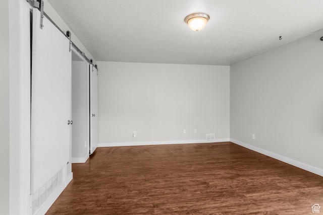 435 W 4800 S, Washington Terrace, UT 84405 - unfurnished bedroom featuring a barn door, dark wood-type flooring, and baseboards
