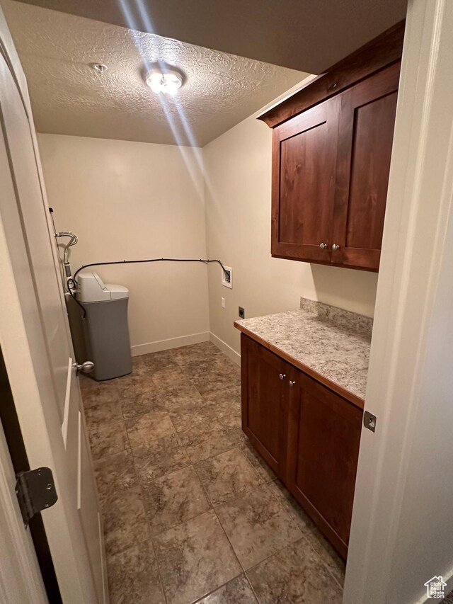 1045 S 1700 W Unit 1121, Payson, UT 84651 - clothes washing area featuring a textured ceiling, hookup for an electric dryer, washer hookup, baseboards, and cabinet space