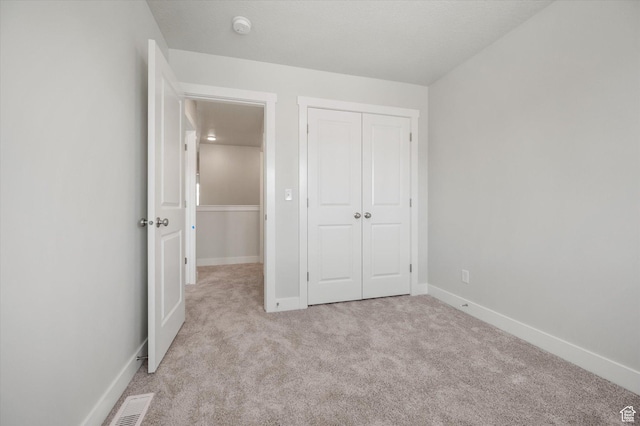 635 S 85 E Unit 26, Smithfield, UT 84335 - unfurnished bedroom featuring baseboards, visible vents, a closet, and light carpet