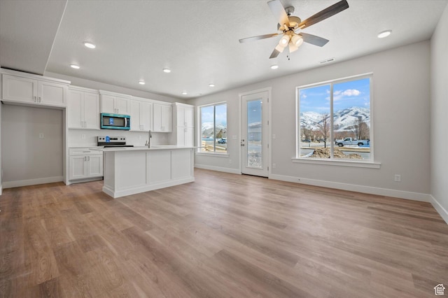 635 S 85 E Unit 26, Smithfield, UT 84335 - kitchen featuring stainless steel microwave, electric range, plenty of natural light, white cabinets, and a sink