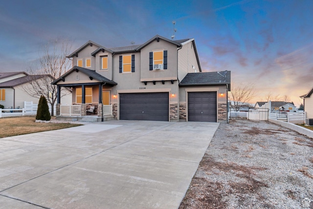 1114 Alexander Ct, Grantsville, UT 84029 - view of front of house with driveway, stone siding, a gate, fence, and a porch