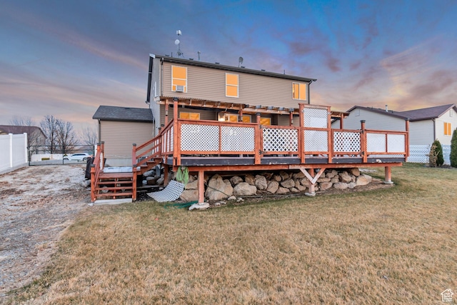 1114 Alexander Ct, Grantsville, UT 84029 - back of house at dusk with fence, a lawn, and a wooden deck