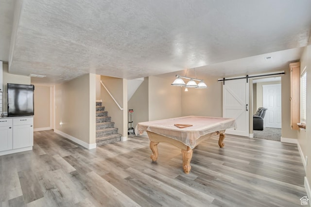 1114 Alexander Ct, Grantsville, UT 84029 - playroom featuring a textured ceiling, a barn door, light wood-style flooring, billiards, and baseboards