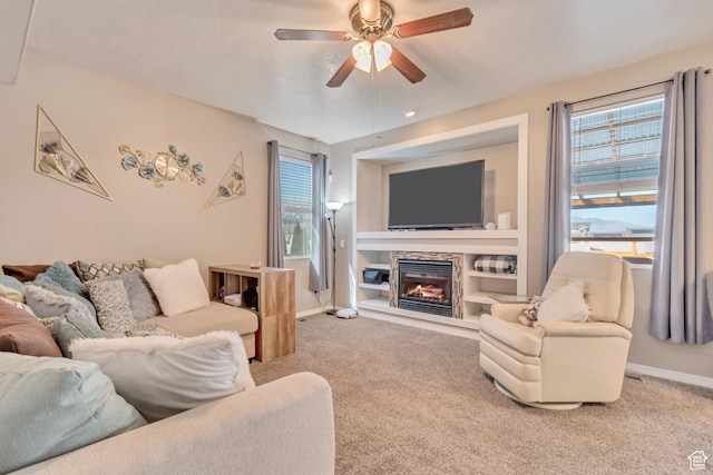 1114 Alexander Ct, Grantsville, UT 84029 - carpeted living area featuring built in shelves, a glass covered fireplace, baseboards, and a ceiling fan