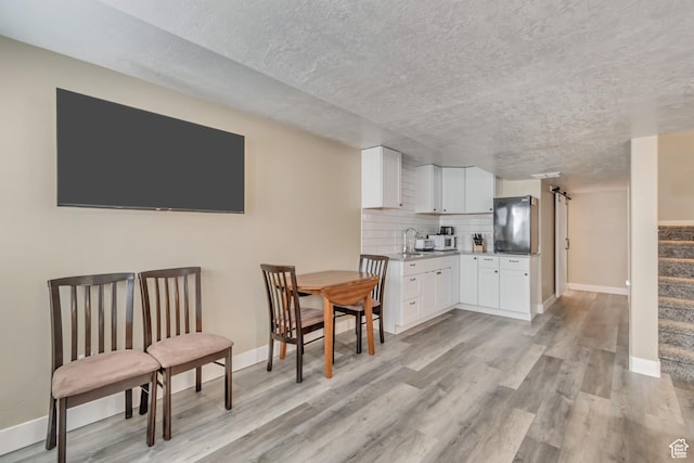 1114 Alexander Ct, Grantsville, UT 84029 - kitchen with tasteful backsplash, freestanding refrigerator, light wood-type flooring, and white cabinets