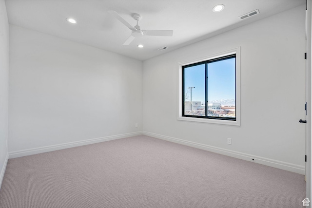 empty room featuring baseboards, visible vents, and light colored carpet