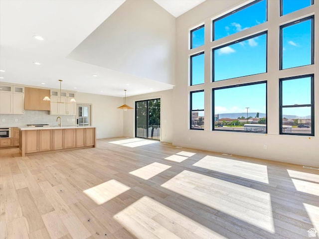unfurnished living room with light wood-type flooring, plenty of natural light, and recessed lighting