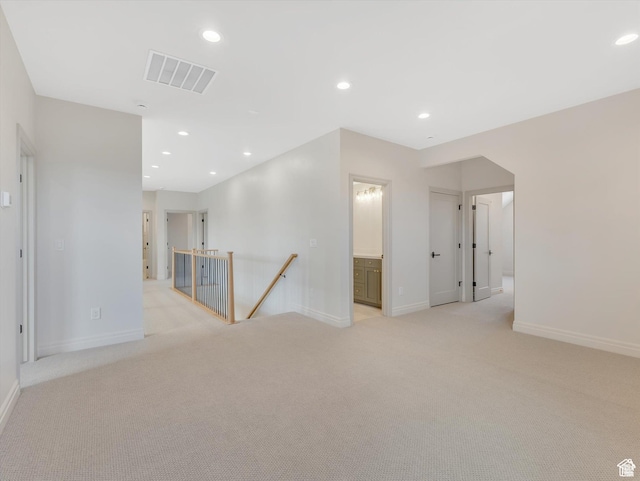 spare room featuring baseboards, recessed lighting, visible vents, and light colored carpet