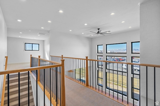 corridor with recessed lighting, visible vents, and an upstairs landing