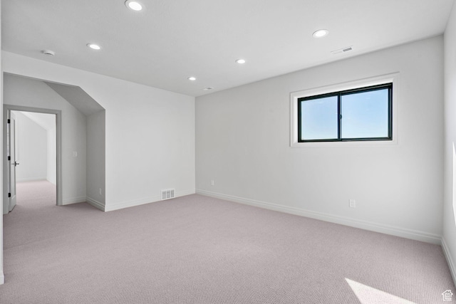 spare room with light carpet, visible vents, and recessed lighting