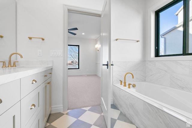 full bath featuring tile patterned floors, baseboards, a garden tub, and vanity