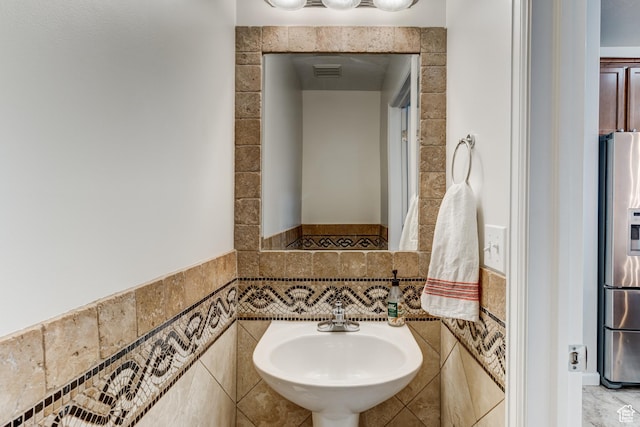 1424 W Stone Meadow Dr, West Jordan, UT 84088 - bathroom featuring visible vents, a wainscoted wall, a sink, and tile walls
