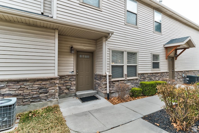 1424 W Stone Meadow Dr, West Jordan, UT 84088 - doorway to property with stone siding and central AC