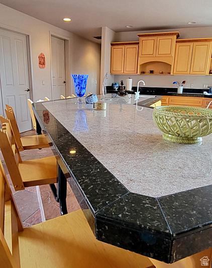 1657 N Kayenta Dr, Ivins, UT 84738 - kitchen with a large island, recessed lighting, dark stone countertops, a breakfast bar area, and a sink