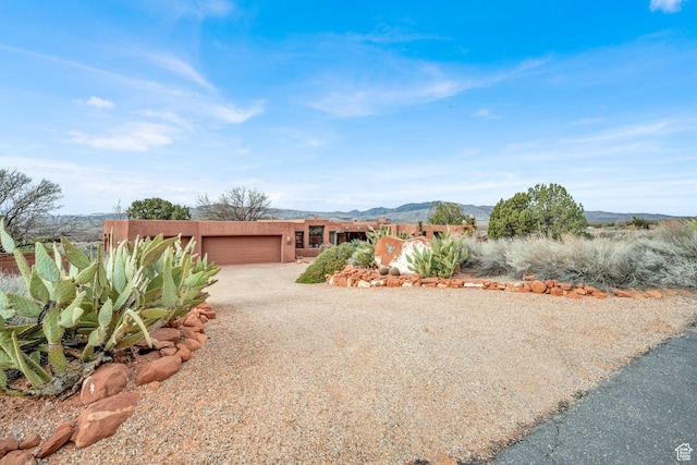 1657 N Kayenta Dr, Ivins, UT 84738 - view of front facade featuring an attached garage, driveway, stucco siding, and a mountain view