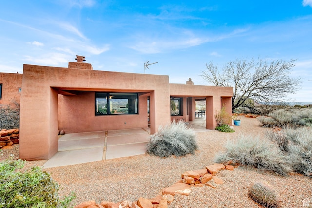 1657 N Kayenta Dr, Ivins, UT 84738 - southwest-style home featuring a chimney, stucco siding, and a patio
