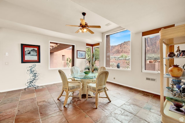 1657 N Kayenta Dr, Ivins, UT 84738 - dining room featuring stone tile flooring, baseboards, a ceiling fan, and a mountain view