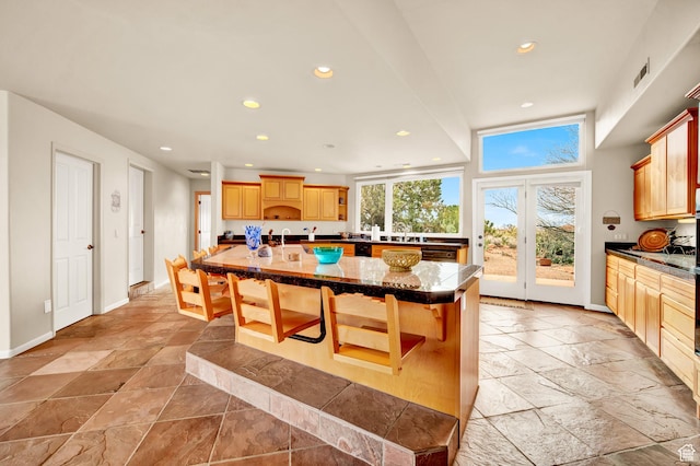 1657 N Kayenta Dr, Ivins, UT 84738 - kitchen with stone tile flooring, recessed lighting, a breakfast bar, dark countertops, and a center island with sink
